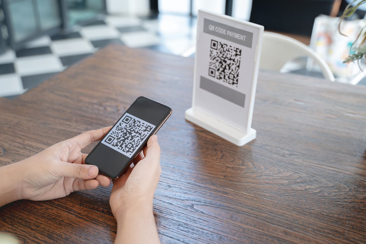 Online money, Close up hand holding smart phone for scanning Qr code for digital payment.